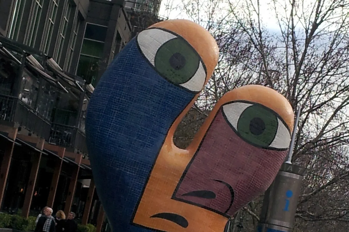 The Ophelia sculpture at Southgate, two large stylised faces in blue, orange and green with painted eyes